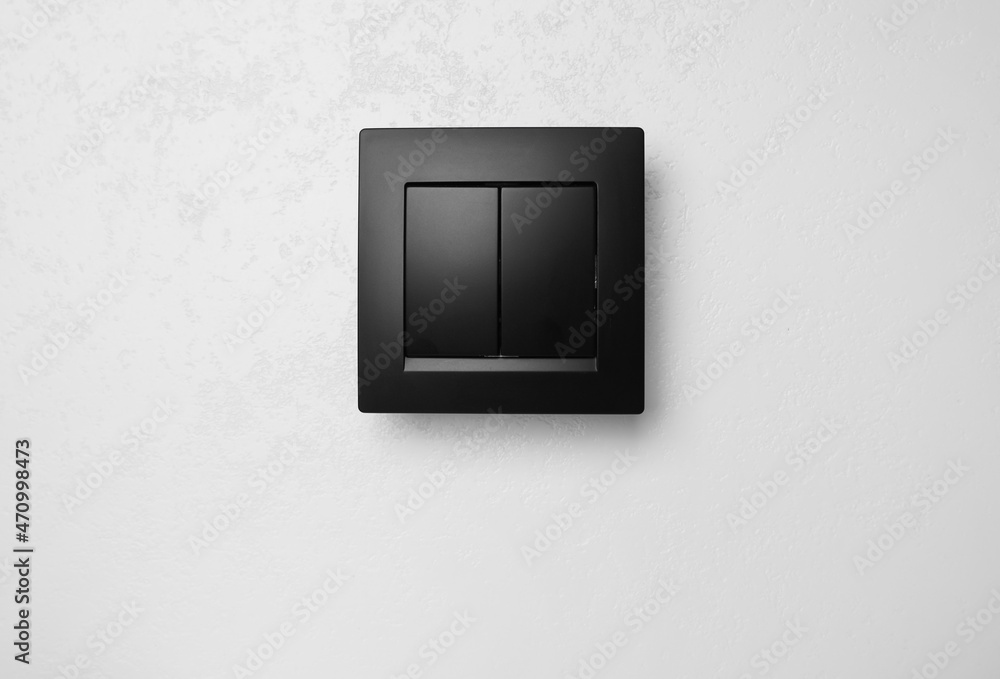 Wall mural black plastic light switch on white background