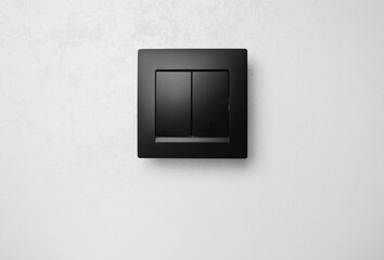 Black plastic light switch on white background
