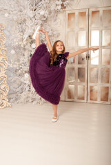 Obraz premium girl 8 years old on the holiday new year and Christmas 2022 dances in a dress against the background of a huge chandelier concept minimalism