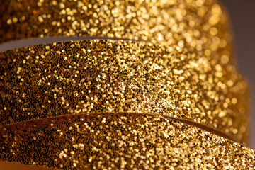 Macro abstract texture background of sparkling gold color Christmas holiday glitter ribbon with...