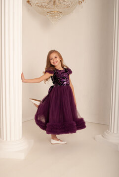 girl 8 years old on the holiday new year and Christmas 2022 dances in a dress against the background of a huge chandelier concept minimalism