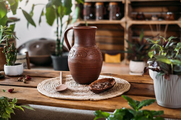 Jug with hot organic cacao for ceremony, closeup. Healthy drink from raw cocoa beans in green vegetarian cafe Copy space, ritual for harmony in green rustic place