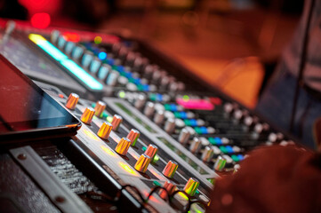 Naklejka premium Audio Mischpult mit bunten Knöpfen und Drehreglern während einer Live-Veranstaltung