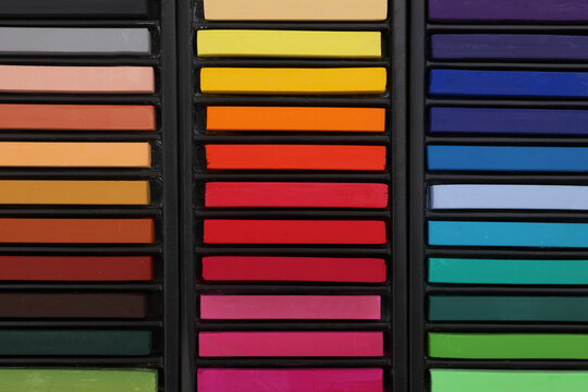 Set of colorful pastels in trays as background, top view. Drawing materials