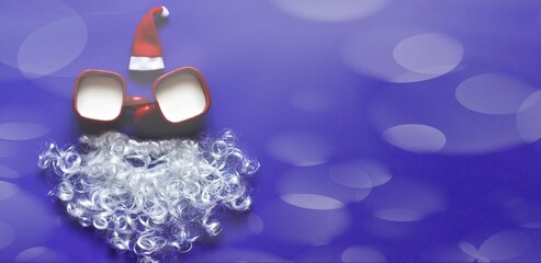 Creative Santa Claus made from cups of milk, white beard and hat on a velvet violet background.  Bokeh background. Christmas and new year greeting card