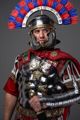Antique pensive legionary posing against gray studio background