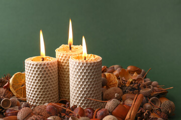 Beautiful burning candles and autumn decor on color background