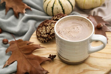 Cup of tasty pumpkin coffee on plaid