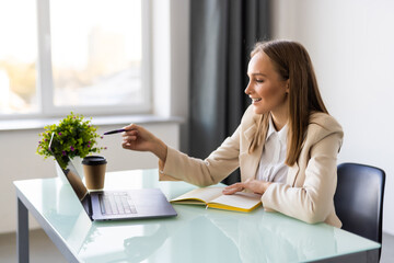 Portrait of businesswoman sitting at desk calculating finance in office