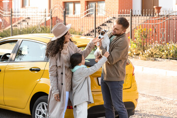 Fototapeta premium Happy family with cute dog near yellow car outdoors