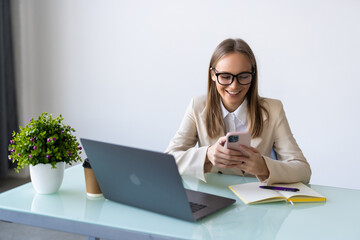 Young Businesswoman uses smart phone in office environment