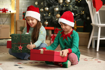 Happy little children with gifts at home on Christmas eve