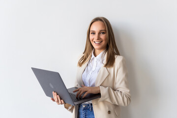 Successful business woman is standing with laptop on white background.