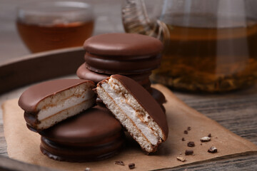 Tasty choco pies and tea on wooden tray, closeup view © New Africa