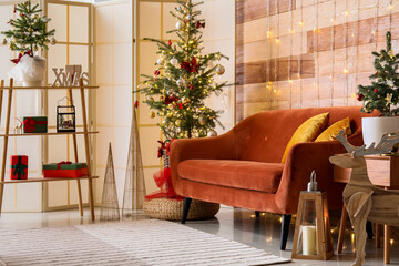 Interior of stylish living room with red sofa, Christmas trees and glowing lights