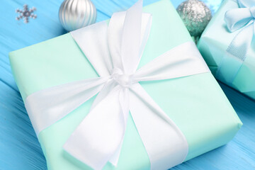 Beautiful Christmas gift on blue wooden background, closeup