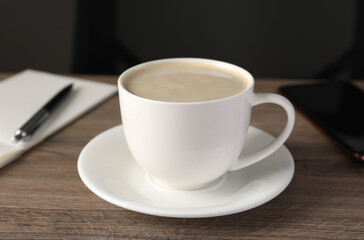 Fototapeta na wymiar Coffee Break at workplace. Cup of hot drink on wooden table