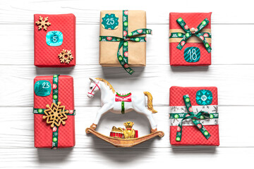 Handmade wrapped red, green gift boxes decorated with ribbons, snowflakes and numbers, Christmas decorations and decor on white table Xmas advent calendar concept Top view Flat lay Holiday card
