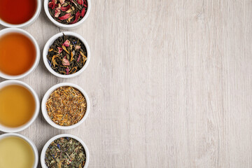 Flat lay composition with different freshly brewed teas and dry leaves on wooden table. Space for text