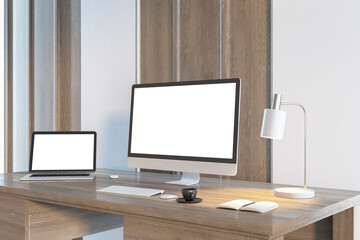 Simple designer desktop with empty white computer and laptop screens in wooden interior in daylight. Workplace concept. Mock up, 3D Rendering.