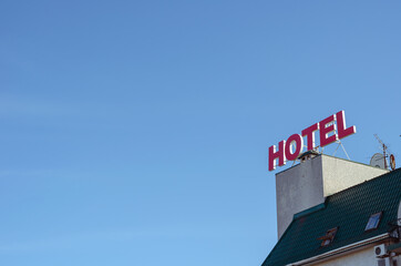The red neon sign for the HOTEL on the roof of the building.