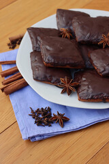 Italian traditional festive cookies called Mostaccioli or Mustaccioli on a plate on blue napkin on wooden table. Christmas cookies made mith Pisto, a mix of various spices
