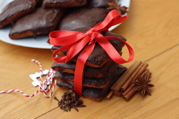 Stack of traditional italian Mostaccioli cookies tied with red ribbon on wooden table