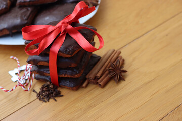 Stack of traditional italian Mostaccioli cookies tied with red ribbon on wooden table