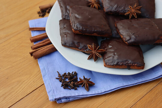 Italian traditional festive cookies called Mostaccioli or Mustaccioli on a plate on blue napkin on wooden table. Christmas cookies made mith Pisto, a mix of various spices