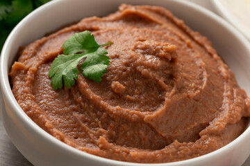 Bowl with brown refried beans paste close up