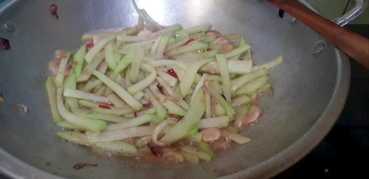 cooking chayote on a frying pan