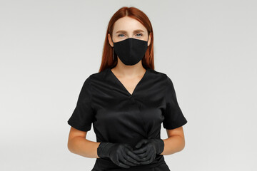 Redhead female sugaring master in black robe gloves and mask
