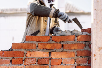 man building brick wall, bricklayer