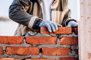man building brick wall, bricklayer