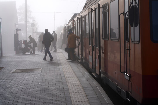 People getting off train at railway station Uetliberg on a foggy autumn day. Photo taken November 19th, 2021, Zurich, Switzerland.
