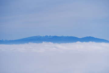 Sea of fog with Swiss alps in the background and cloudy blue sky on a autumn day. Photo taken November 19th, 2021, Zurich, Switzerland.