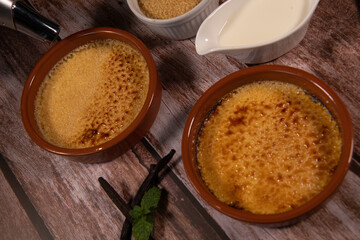 Chef cooks creme brulee with gas burner, dessert in the home kitchen, Cooking at home, professionals for food blog. High quality photo