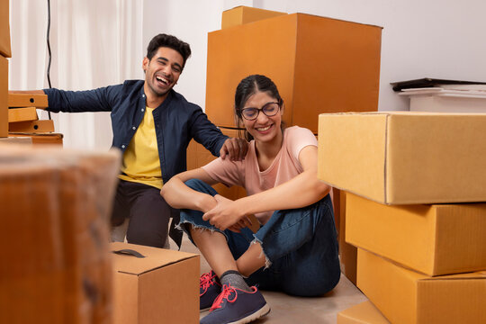 Adult boy and girl having fun during packing 