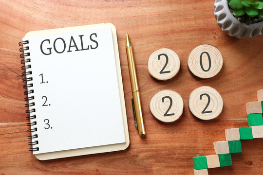 Business concept of top view 2022 goals list with notebook over wooden desk