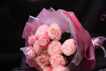 Beautiful pink roses bouquet on black background. Florist shop wallpaper.