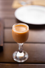 Cream liqueur in tiny glass on the restaurant table.