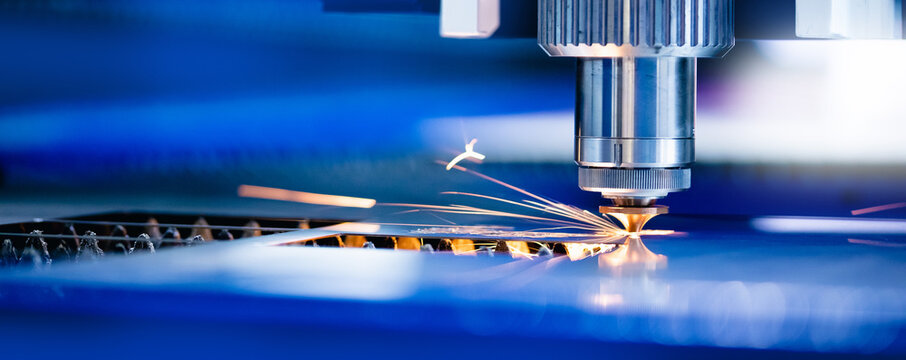 Concept banner background modern industrial technology. CNC Laser engraving cutting of heavy metal with light spark