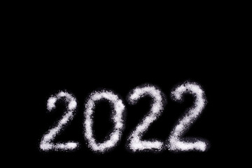 Happy new year 2022. Date 2022 written with salt like snow isolated on black background. A creative overlay object for a postcard
