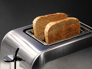 chrom toaster with wholemeal bread slices isolated on black background