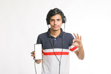 young man using headphone and showing smartphone on white background.