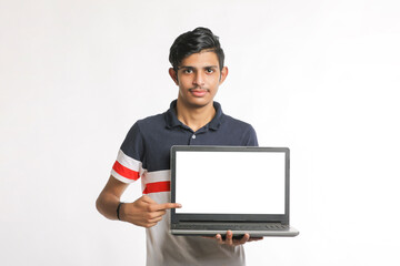 Young indian successful man showing laptop screen over white background.