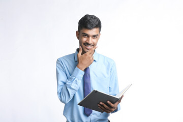 Young indian businessman cheaking or reading dairy on white background.