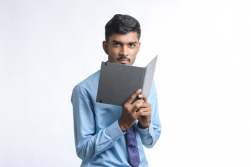 successful Young Indian businessman or employee wearing Suit and cheaking dairy on white background.