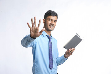 successful Young Indian businessman or employee wearing Suit and cheaking dairy on white background.