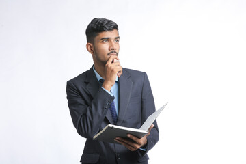 Young indian man holding diary in hand and thinking some idea